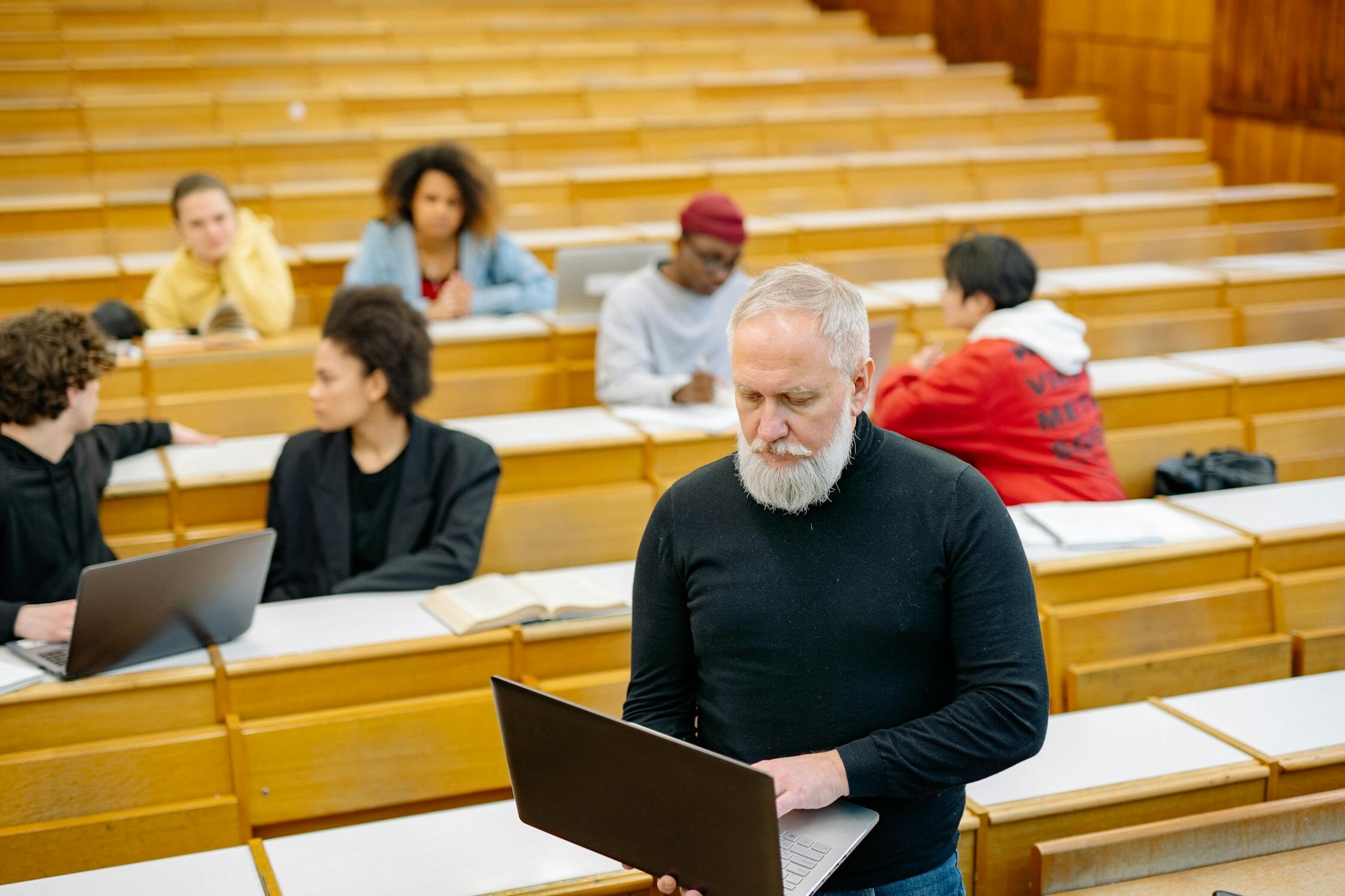 Adult learners in classroom with laptops