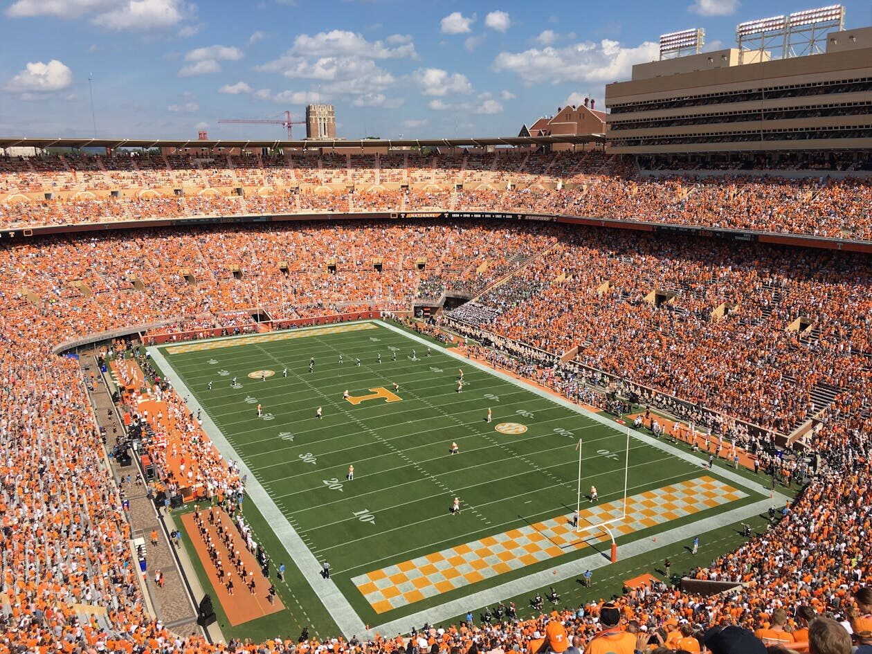 Packed college football stadium with fans cheering during game